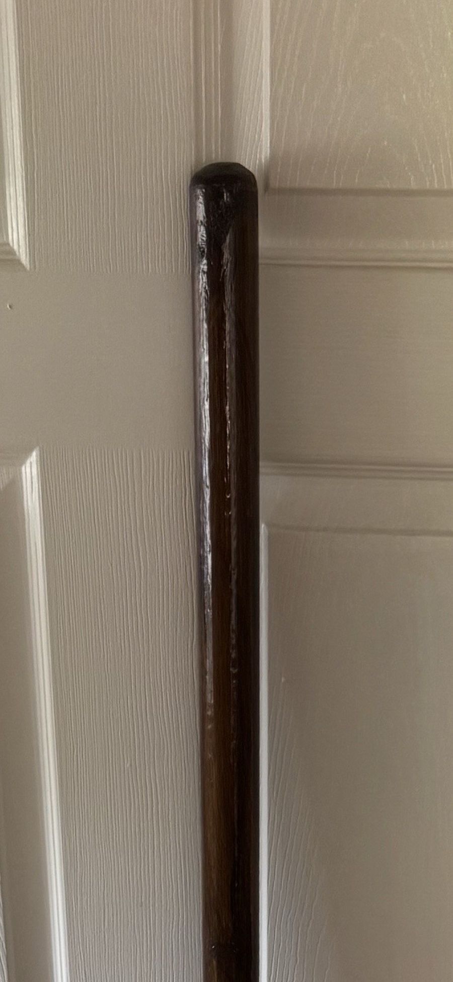 The full length of a pole stood upright indoors