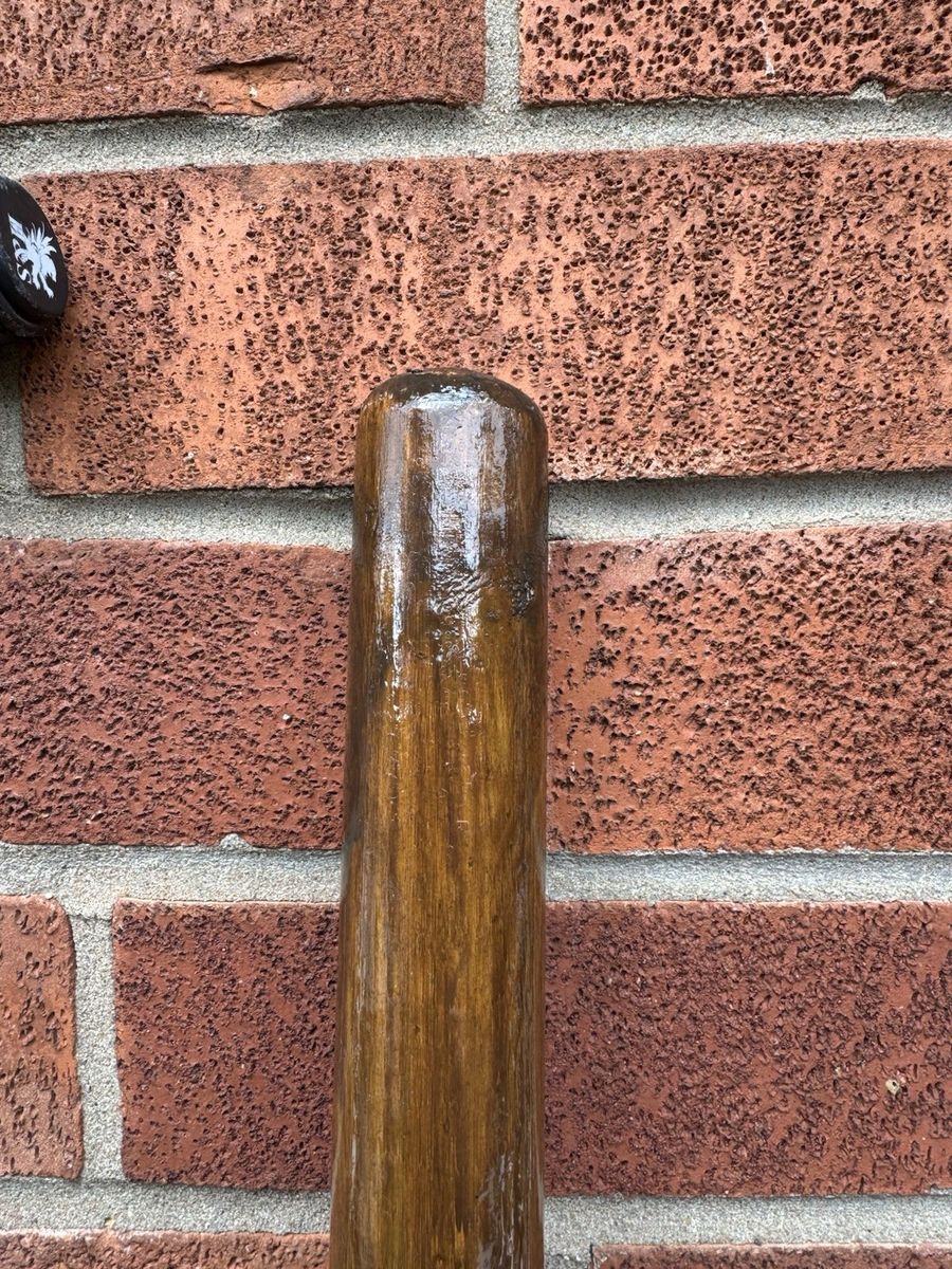 Close-up of the pole showing the natural grain under hand-applied varnish